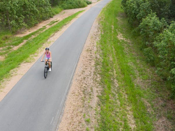 Wamuran Rail trail - a woman cycling on a barren bike track.