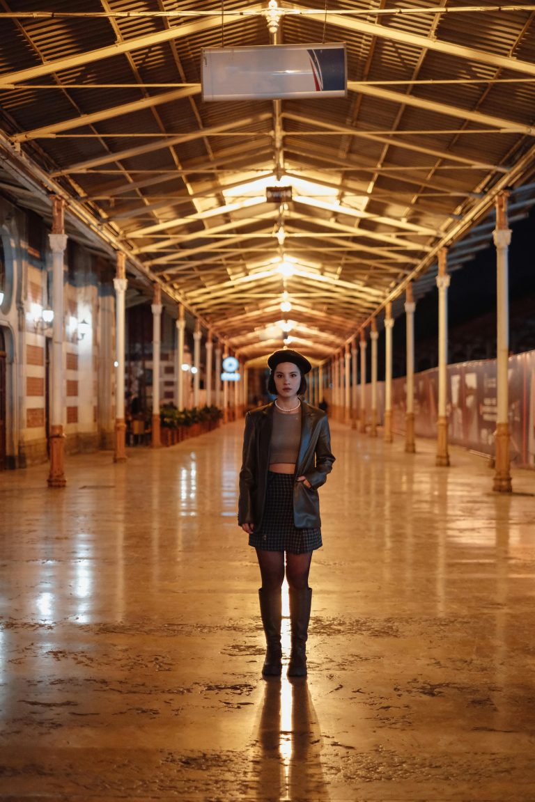 Woman at empty train station alone at night
